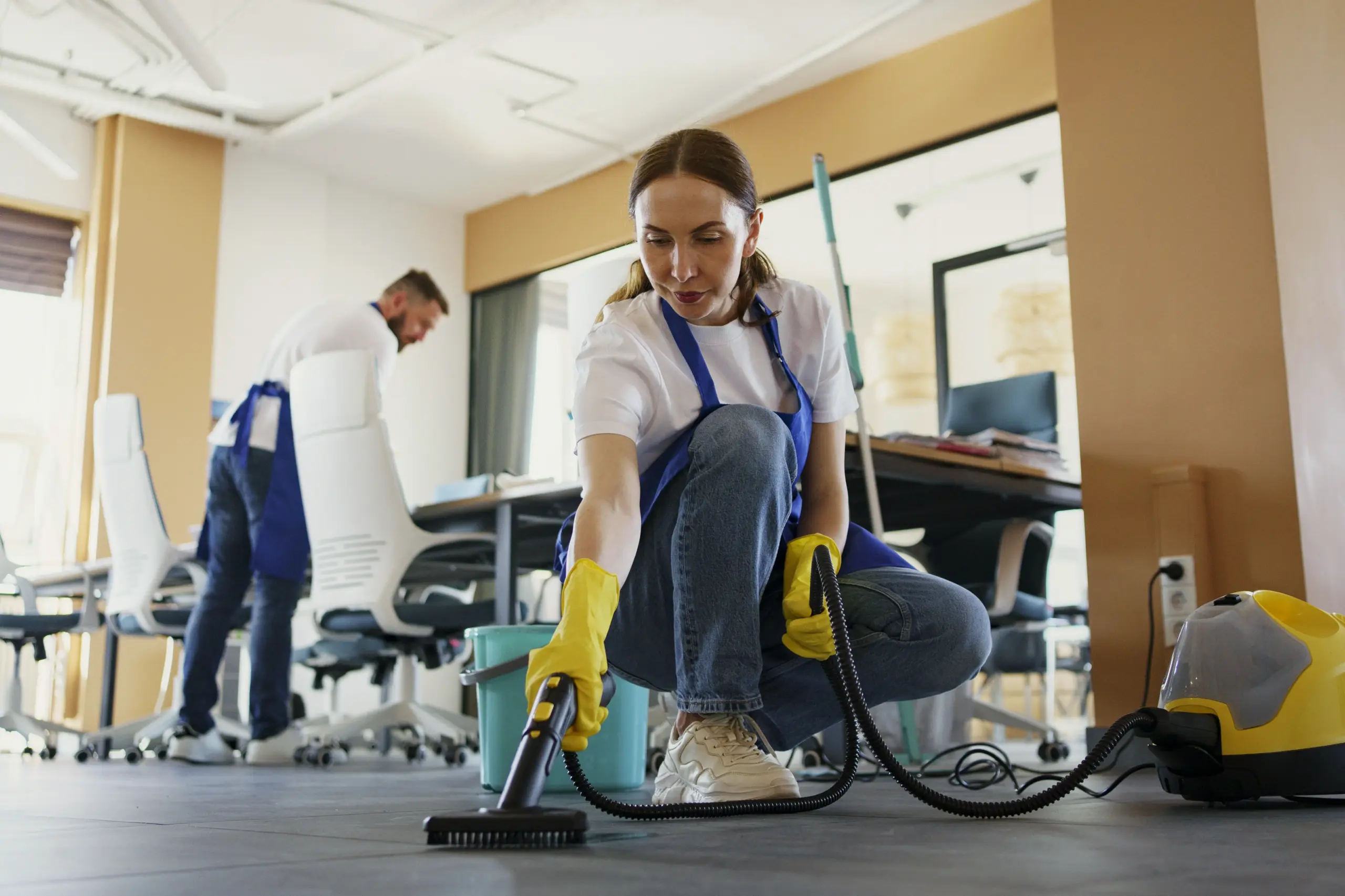 professioneller-reinigungsdienstmitarbeiter-der-im-buro-einen-staubsauger-verwendet